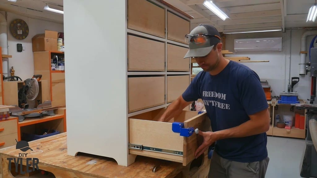 man using nail gun for drawer front installation