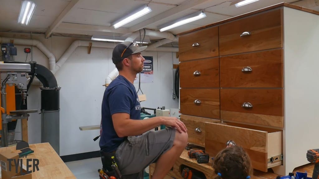 man looking at completed installation of cherrywood drawer fronts for dresser