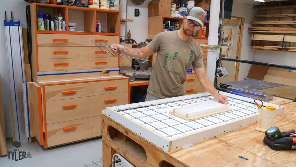 man installing galvanized fencing around negative impression of melamine form