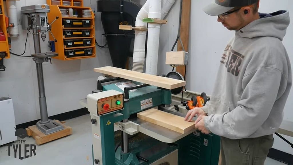 man running spalted maple board through planer