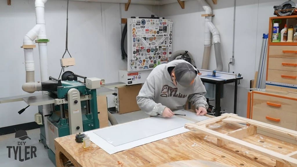 man tapping edge of glass sheet