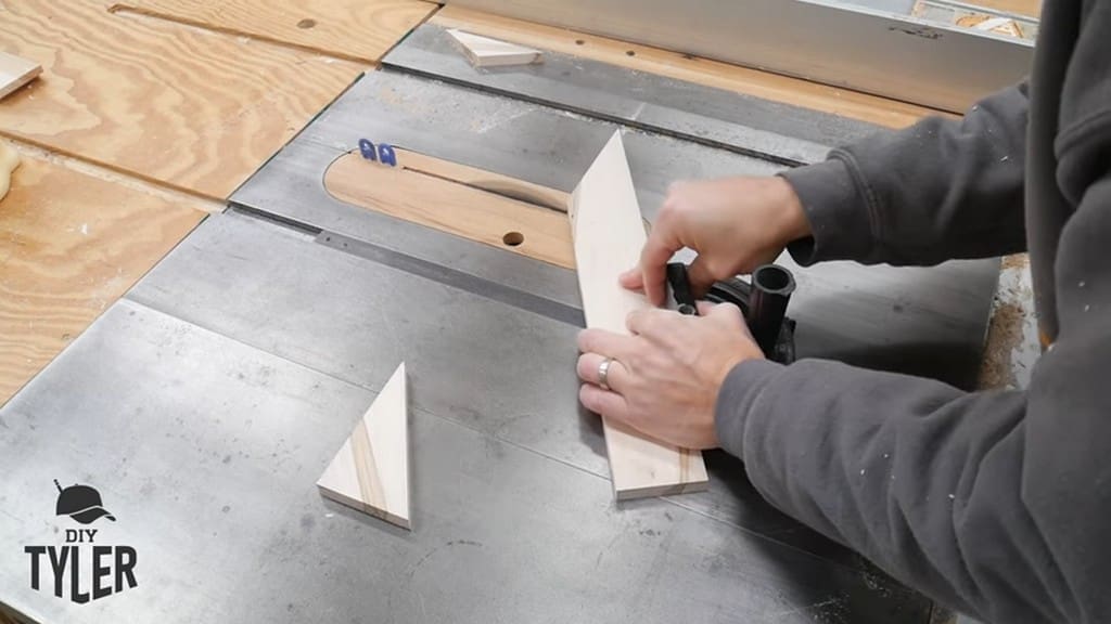 man running angled corner piece through table saw