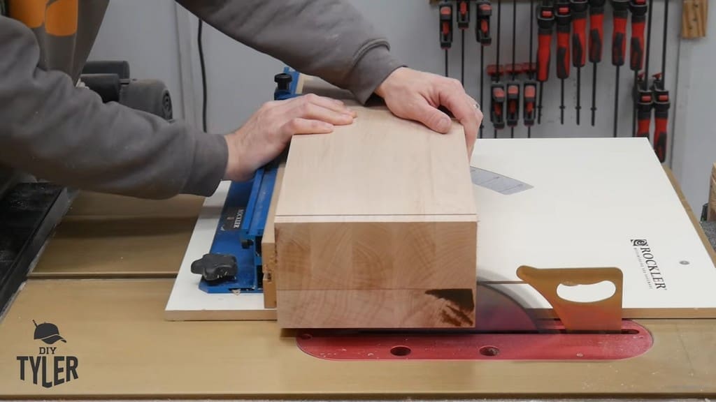 man running hard maple wood through table saw