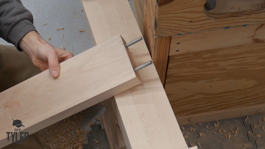 man demonstrating cross-brace piece for DIY D&D game table