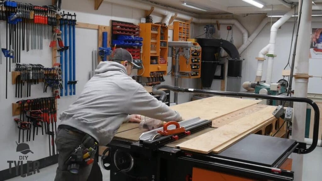 man cutting plywood at table saw