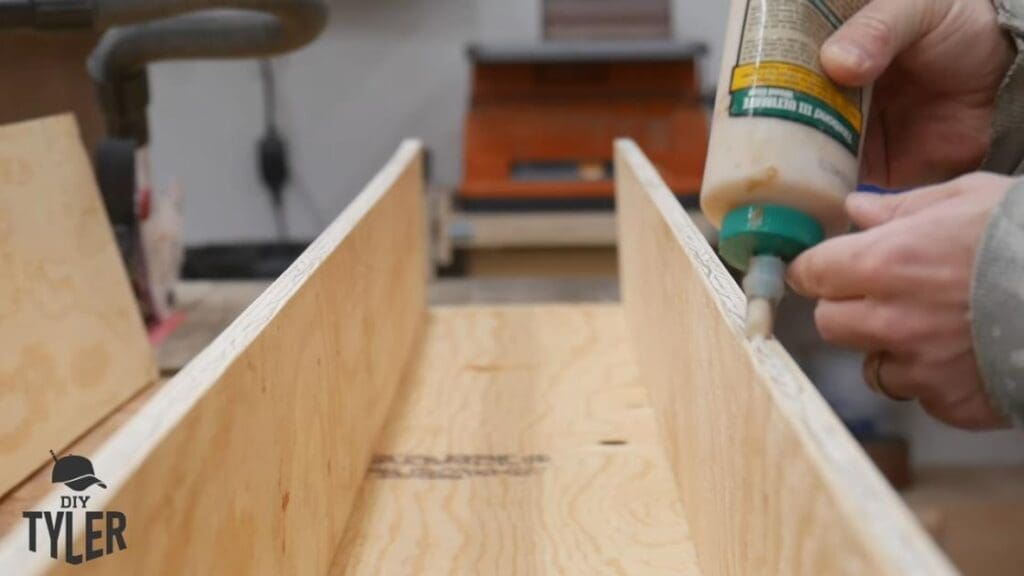 man applying titebond iii glue to plywood pieces
