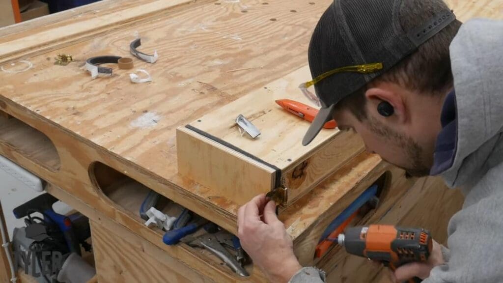 man affixing hinge to door of steam box