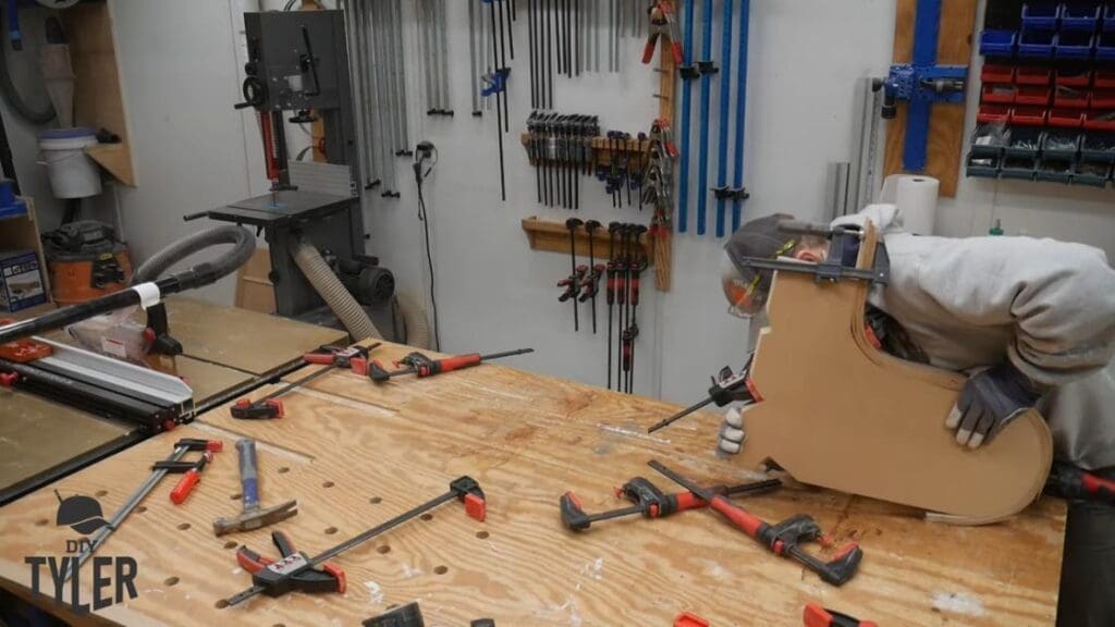man bending steam-treated wood onto mold